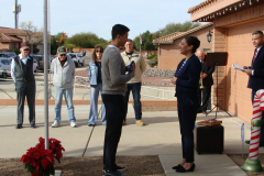 Second Lieutenant John Gallardo receives a flag from his mother, Anna, for the family's flag pole.
